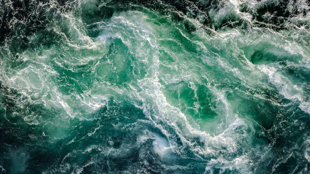 Blue waves of water of the river and the sea meet each other during high tide and low tide.